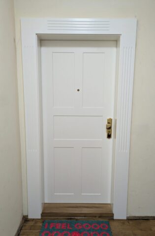 Eingangstür weiß mit Füllungen und messing poliertem Griff